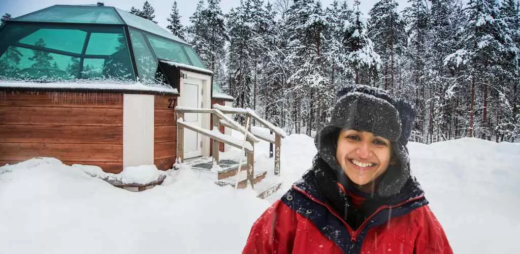 Shwetha, Srijith's wife, stands in front of our enchanting Igloo stay near Ivalo, Finland, during their Finland tour from Chennai